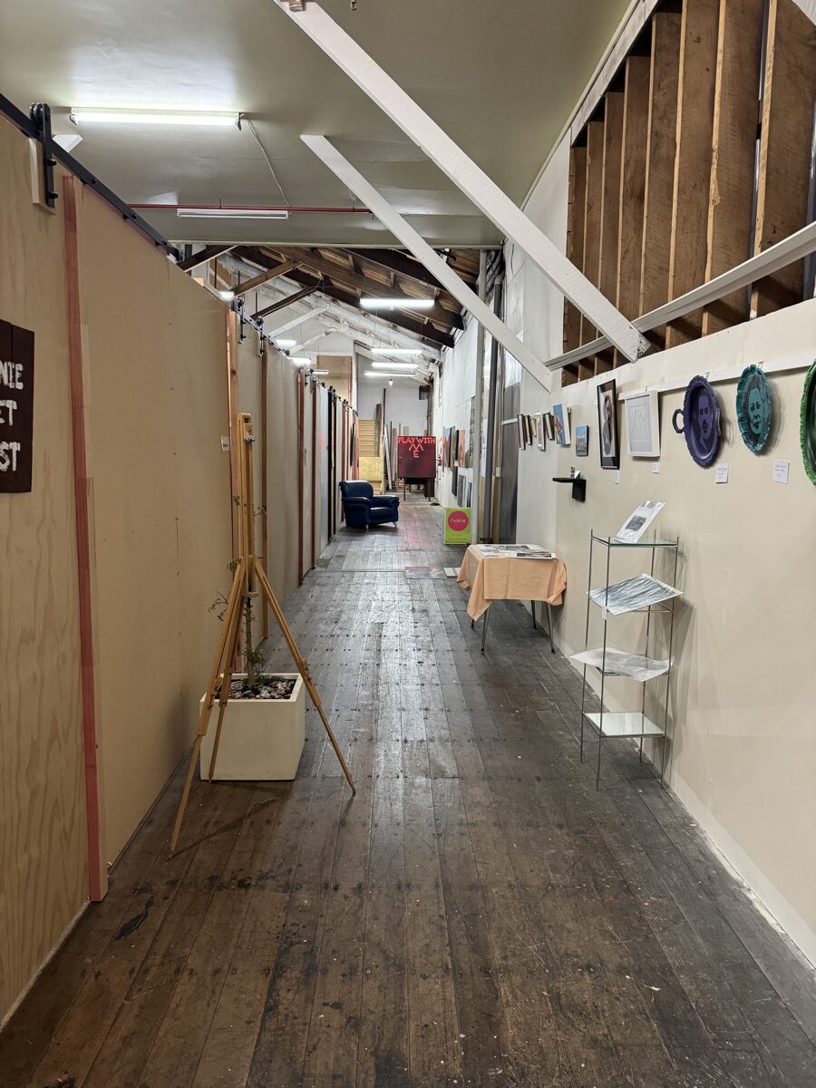Ministry Building 2 Long timber-floored corridor lined with artist studios, an easel and artwork on the walls